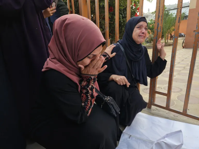 فلسطينيات يذرفن الدموع على أقارب استشهدوا في مجزرة بخان يونس جنوب القطاع (الأناضول)